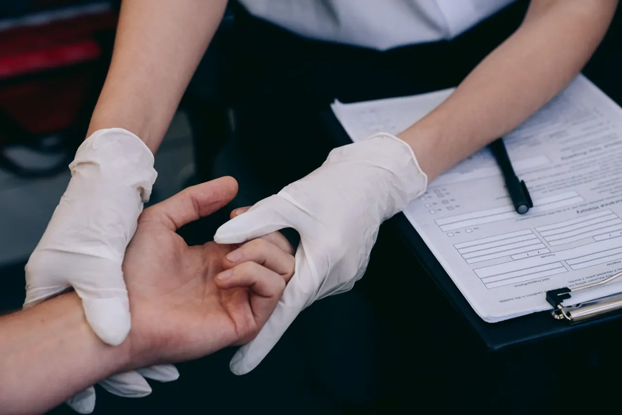 Clinician examining a patient's hand, standing in for the veterinary inspection that must precede a Washington import