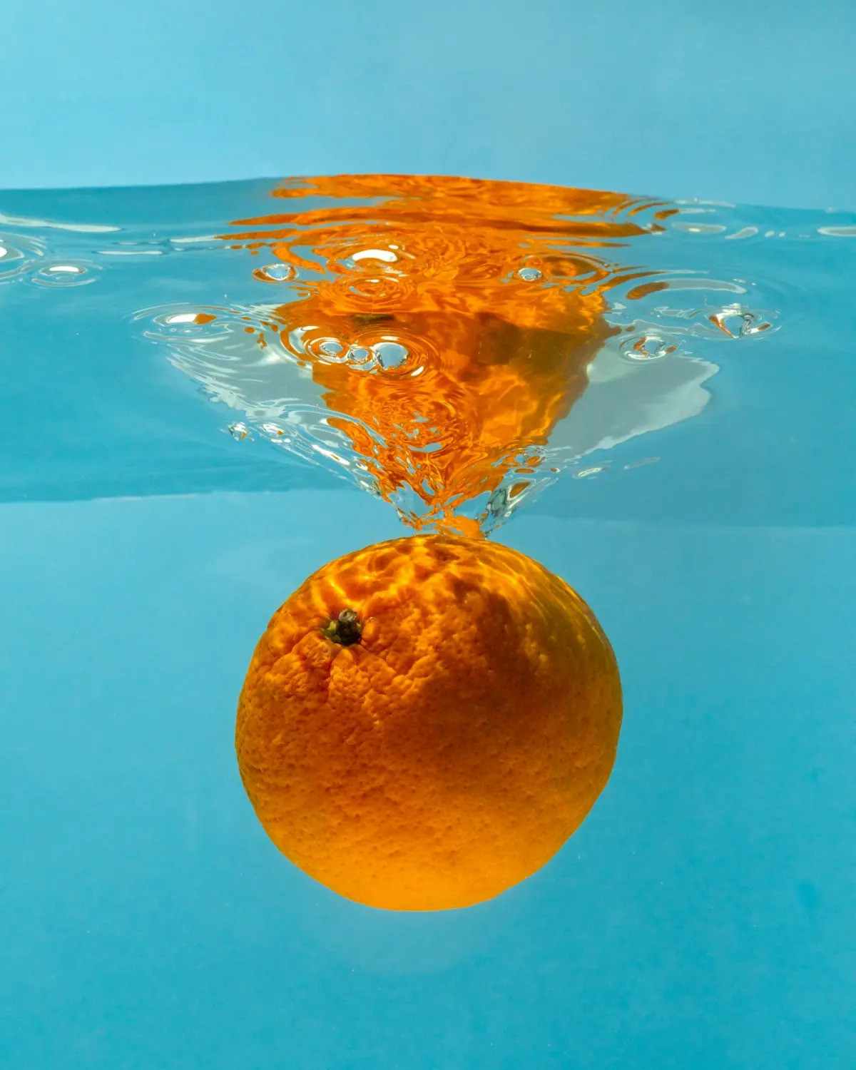 Orange citrus fruit floating in water