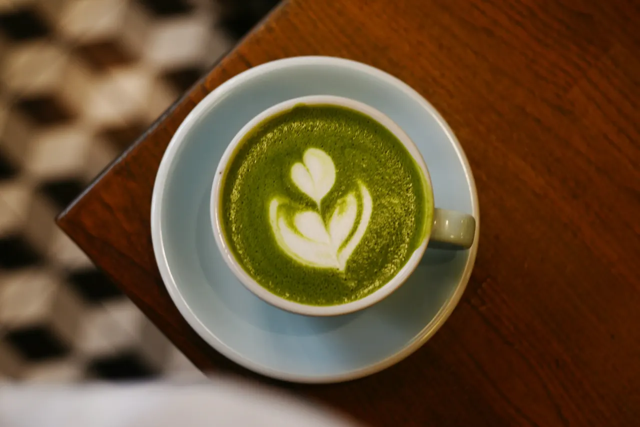 A matcha latte on a cafe counter.