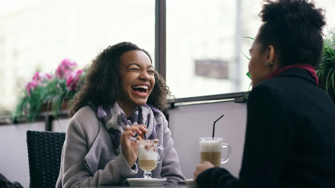 People laughing around a table in a casual bar.